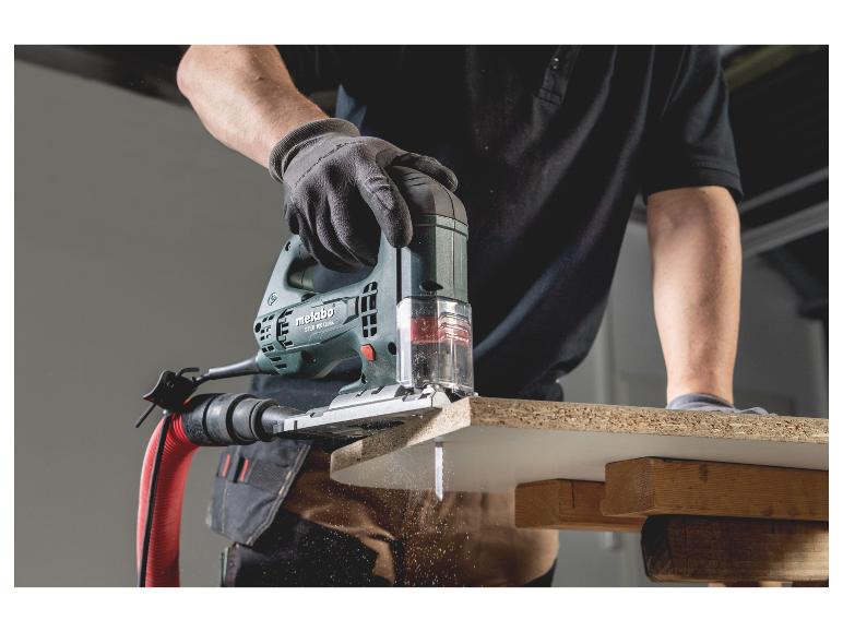Scie sauteuse Metabo coupant du bois, sciure volante.