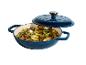 Cocotte bleue avec couvercle, remplie de pommes de terre rôties, champignons et oignons verts.