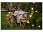 Couple profitant d'une soirée dans le jardin avec mobilier d'extérieur et guirlande lumineuse.