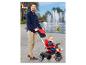 Un homme pousse un tricycle Molto rouge avec un enfant à l'intérieur.