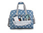 Un sac bleu à pois contenant des fournitures de couture, y compris des ciseaux et un ruban à mesurer.
