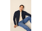 Homme portant un gilet en maille bleu marine zippé, un t-shirt beige et un jean bleu.