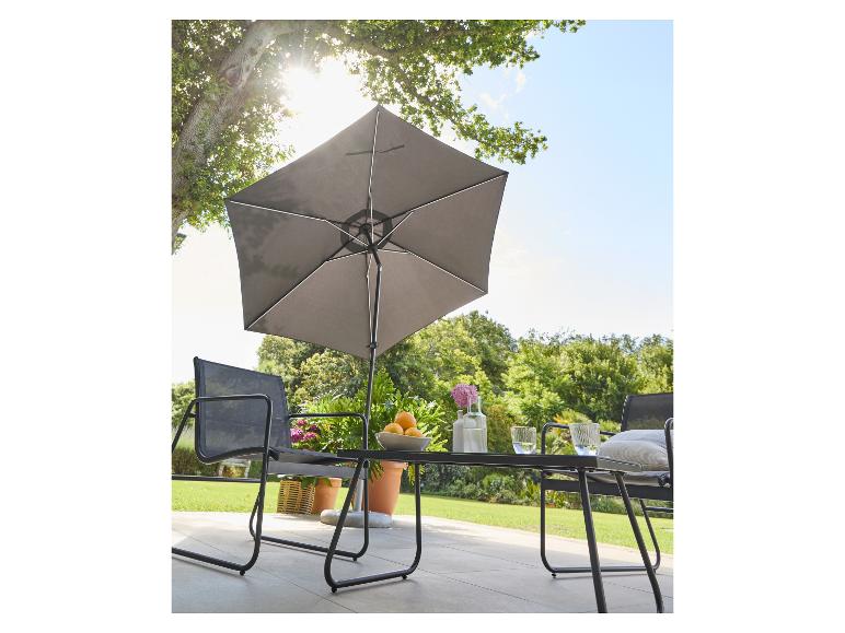 Mobilier de jardin avec parasol, table et chaises sur une terrasse ensoleillée.
