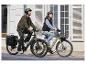 Deux personnes à vélo électrique en ville.