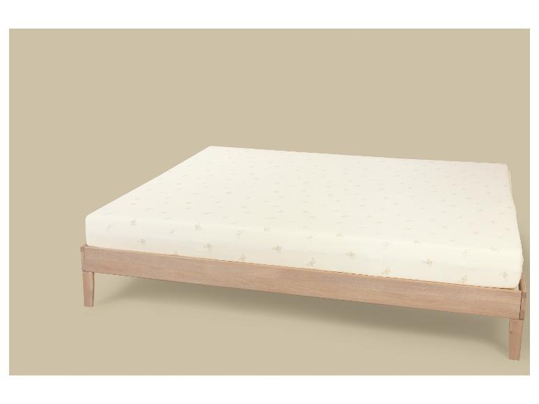 Matelas beige à motif papillon sur un cadre de lit en bois.