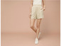 Un mannequin porte des baskets blanches et un short à fleurs.