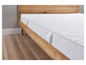 Un matelas blanc sur un cadre de lit en bois.
