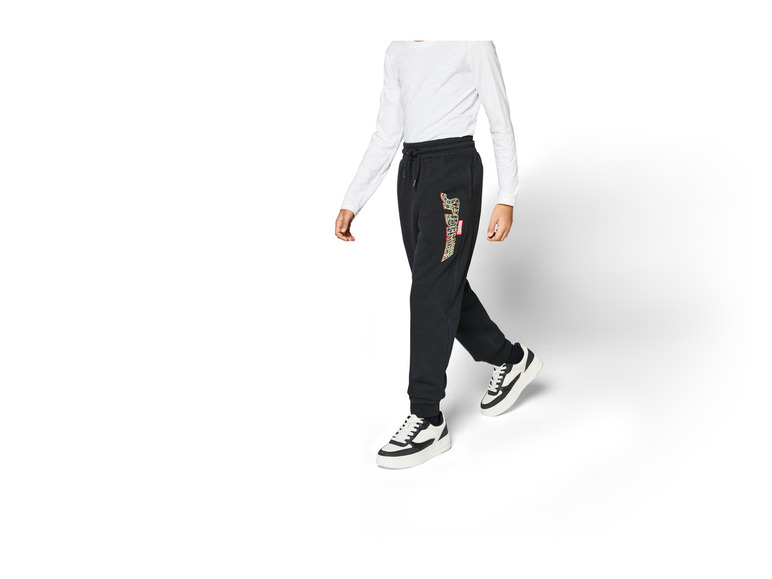 Pantalon de survêtement noir avec imprimé Marvel Spiderman et baskets blanches.