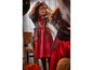 Une fille dans une robe de vampire rouge avec des chauves-souris pour Halloween, se regarde dans le miroir.