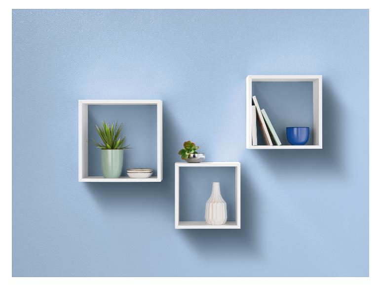 Trois étagères murales blanches avec des plantes, un vase et des livres.