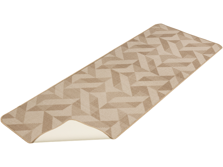 Tapis de couloir beige à motif géométrique, partiellement enroulé pour montrer l'envers.