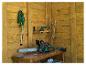Tronçonneuse, taille-haie et ponceuse sur une table en bois dans un abri à outils.