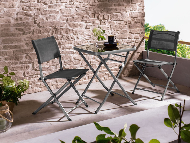 Deux chaises pliantes et une table en verre sur une terrasse