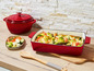 Plat à gratin en fonte rouge avec des légumes rôtis et de la feta.