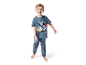 Un jeune garçon souriant porte un pyjama Paw Patrol.