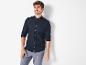 Un homme portant une chemise noire et un pantalon en lin.