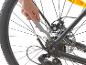 Réparation de vélo : nettoyage de la cassette et de la chaîne avec un outil.