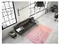 Un tapis rose à motifs en zigzag dans un salon moderne avec un canapé en cuir.