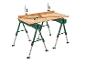 Deux tables de travail vertes avec des pieds réglables et des serre-joints.