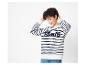 Une femme porte un sweat-shirt rayé avec l'inscription 'Paris'