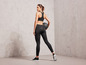 Femme en vêtements de sport noirs avec un ballon de médecine