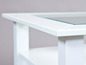 Table basse blanche avec plateau en verre.