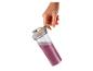Main tenant une bouteille shaker transparente avec un smoothie violet.