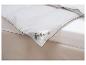 Une couette blanche Fjödur avec des bords verts, posée sur un lit.