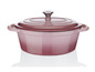 Une cocotte en fonte rose avec un couvercle.