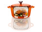 Une cocotte en fonte orange avec un poulet rôti à l'intérieur.