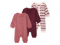 Trois pyjamas pour bébé, un à pois, un uni et un à rayures.