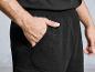 Un homme portant un pantalon noir avec le logo PROG. dans la poche.