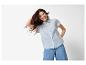 Femme souriante en chemise bleue et jean