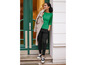 Une femme portant un haut vert, un pantalon noir et des baskets blanches.