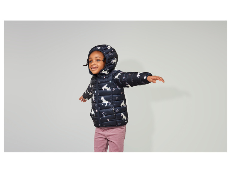 Un enfant porte une veste avec un motif de licorne.