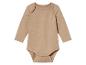 Un body bébé beige à manches longues.