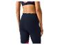 Femme portant un legging de sport bleu marine et un soutien-gorge de sport imprimé.