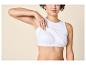Femme en débardeur blanc révélant une brassière de sport blanche en dessous.