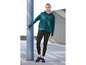 Une femme portant un sweat-shirt à capuche vert Jette Joop et un legging noir.