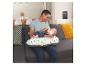 Un père nourrit son bébé au biberon, assis sur un canapé avec un coussin d'allaitement Babybjörn.