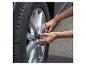 Une personne utilise une clé dynamométrique pour serrer un écrou de roue sur une voiture.