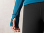 Un sweat-shirt bleu à manches longues avec trous pour les pouces et un legging noir.