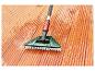 Brosse de terrasse Parkside avec manche télescopique et eau sur un plancher en bois.