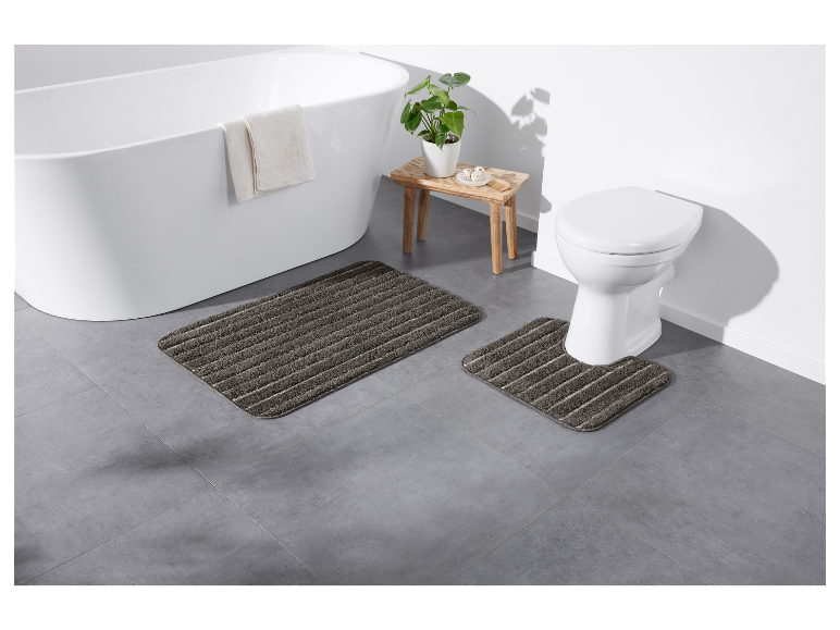 Tapis de bain gris pour la salle de bain, près de la baignoire et des toilettes.