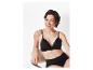Femme souriante portant un soutien-gorge et une culotte noirs en dentelle.