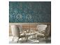 Mur avec papier peint bleu foncé à motif de feuilles dorées et quatre fauteuils confortables autour d'une table.