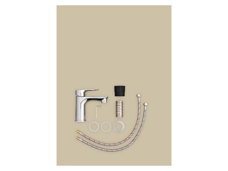 Ensemble de robinet de salle de bain avec robinet argenté, tuyaux flexibles et accessoires sur fond beige.
