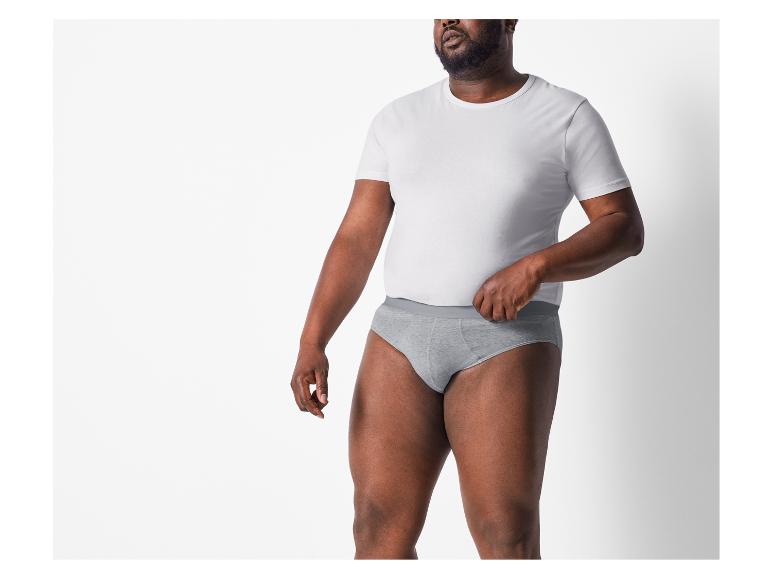 Homme en t-shirt blanc et caleçon gris.