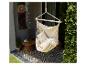 Fauteuil suspendu sur une terrasse avec carrelage à motifs et plantes.