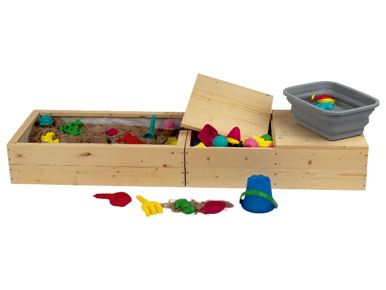 Un bac à sable en bois avec un couvercle, un seau et des jouets.